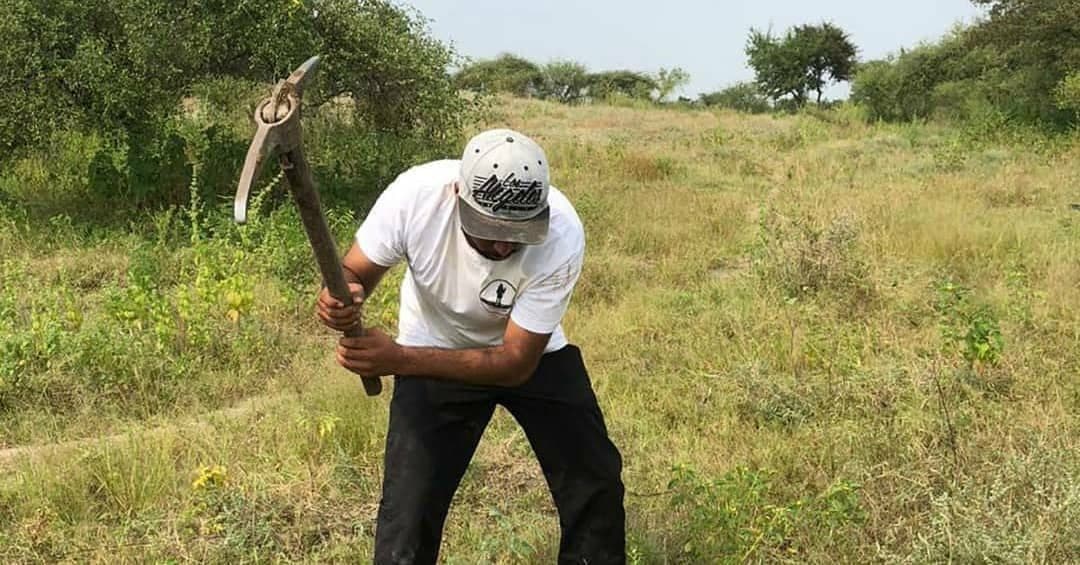 A volunteer digging a pit for a sapling, Laling–Landor, 2021